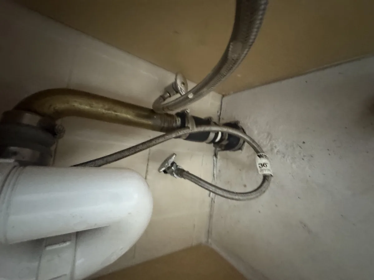 Under-sink pipe openings inspected for rodent entry in Astoria